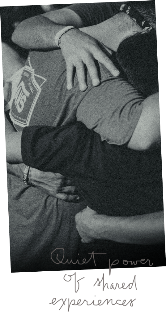 a group of sad young men stand in a group embrace