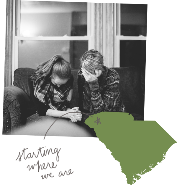 Two women sit crying on a couch