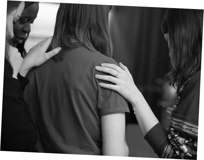 a group of three women comforts another woman